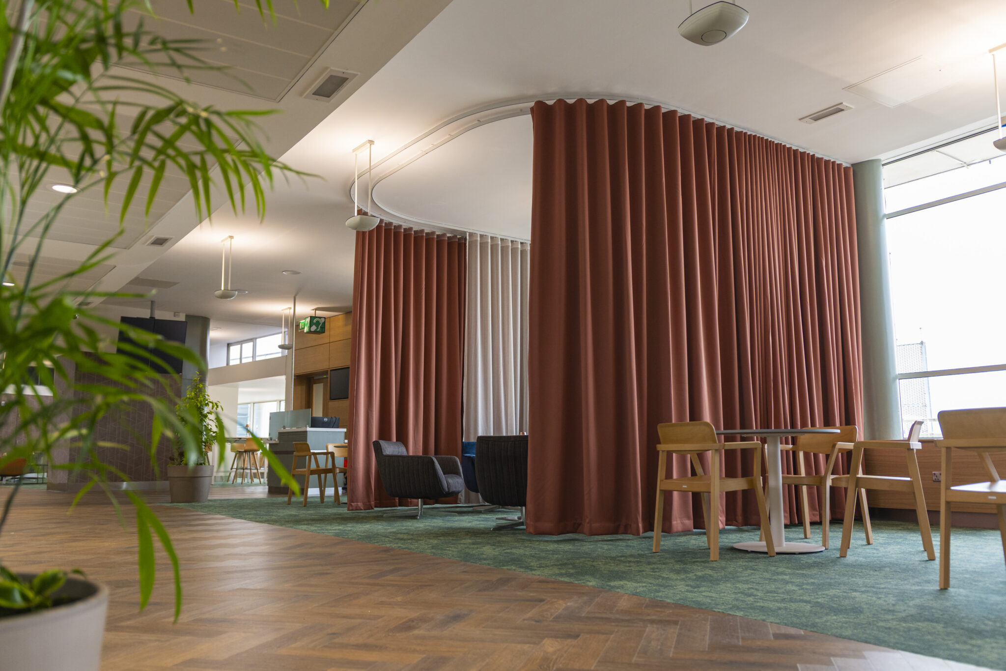 Bespoke curved CWF curtain track with terracotta wave curtains at the Dublin Airport EU Presidency Lounge