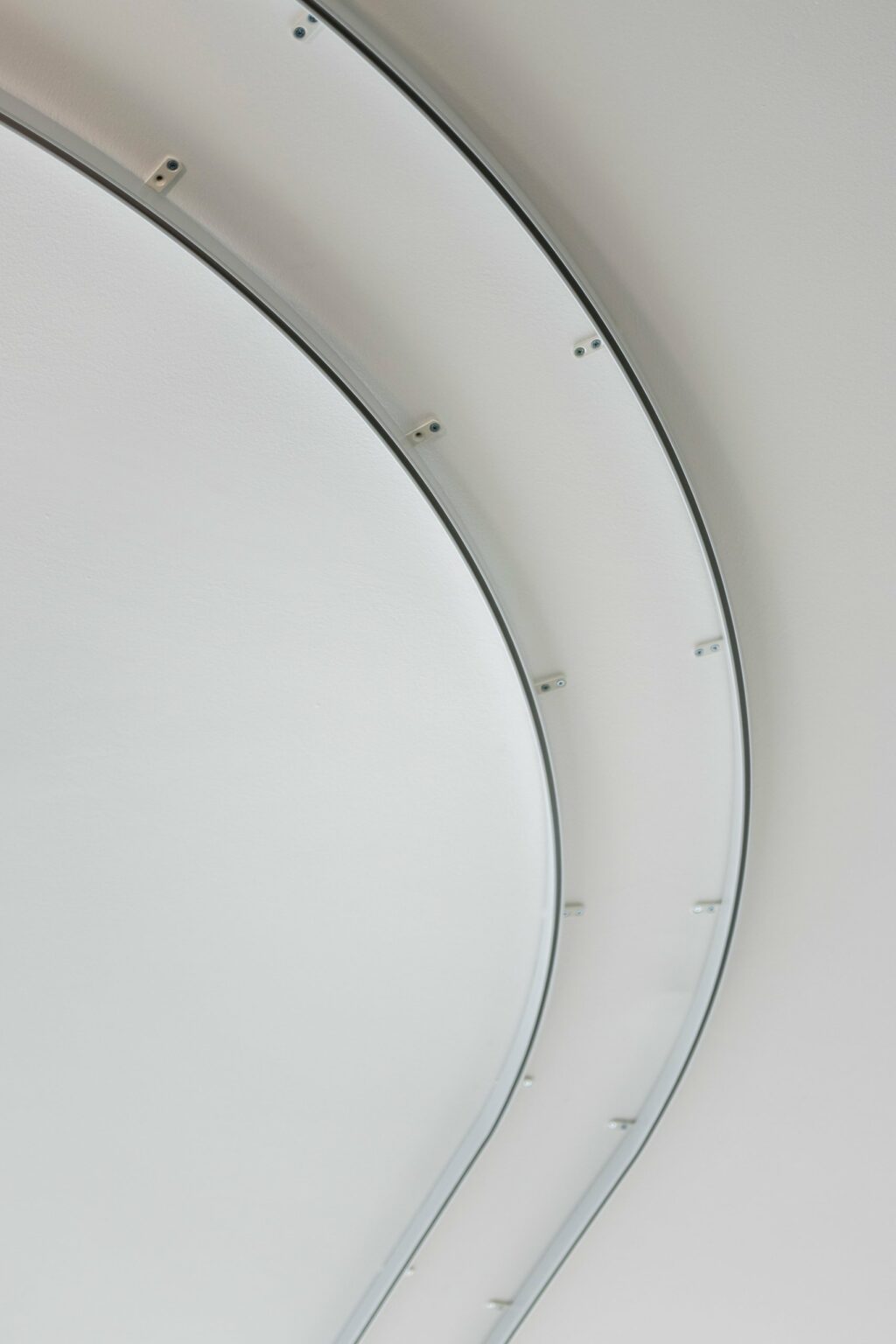 Bent white 5001 curtain tracks following the curved ceiling at Dublin Airport