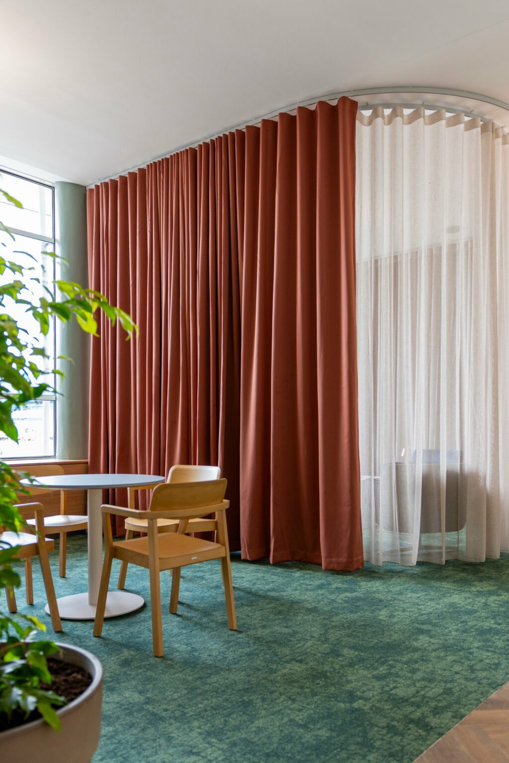 Terracotta Bossa FR wave curtain beside a Proof FR voile on a bent track, Dublin Airport