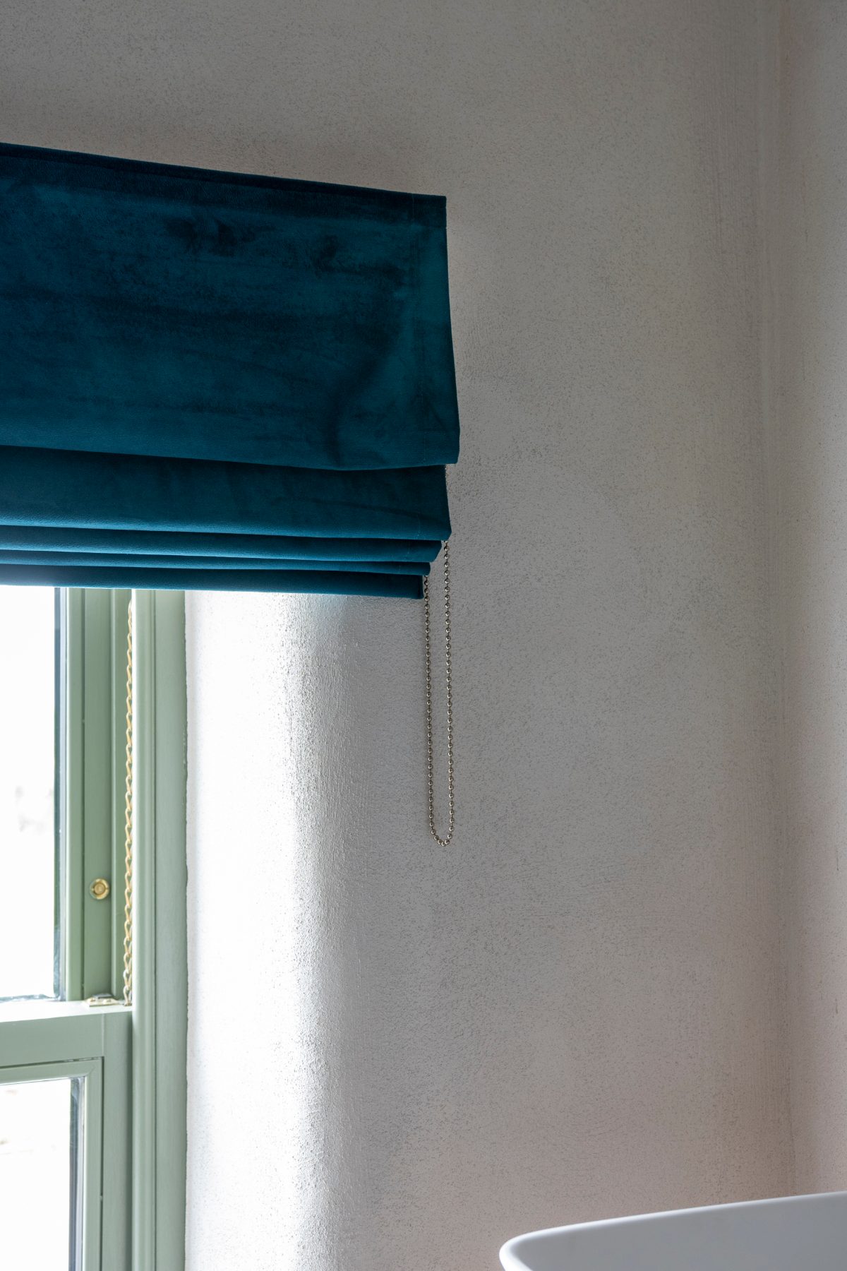 Made to measure Roman blind in teal velvet with a metal bead chain