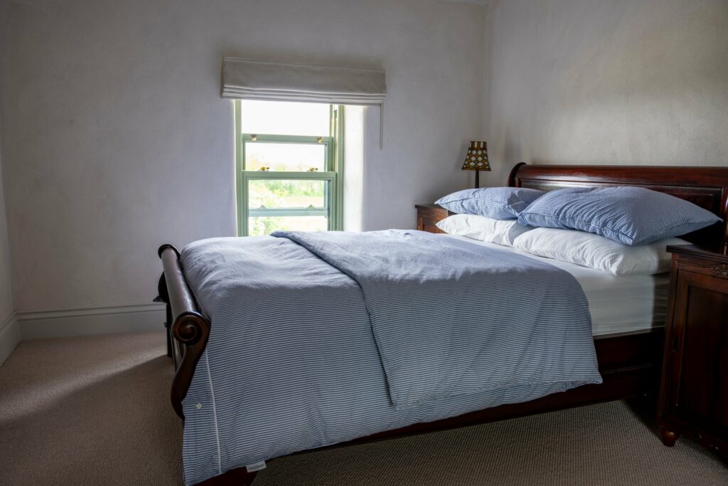 Period bedroom in a restored Midlands stone house with a made-to-measure Roman blind