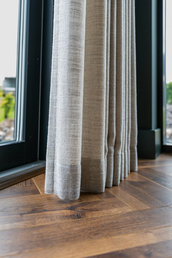 Hem detail of a made-to-measure Infusion curtain on herringbone timber floor