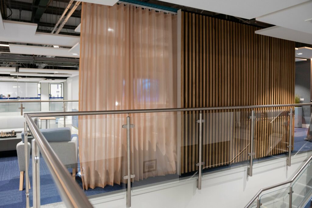 Curtain wrapping a structural column beside a glass balustrade at PGIM Letterkenny